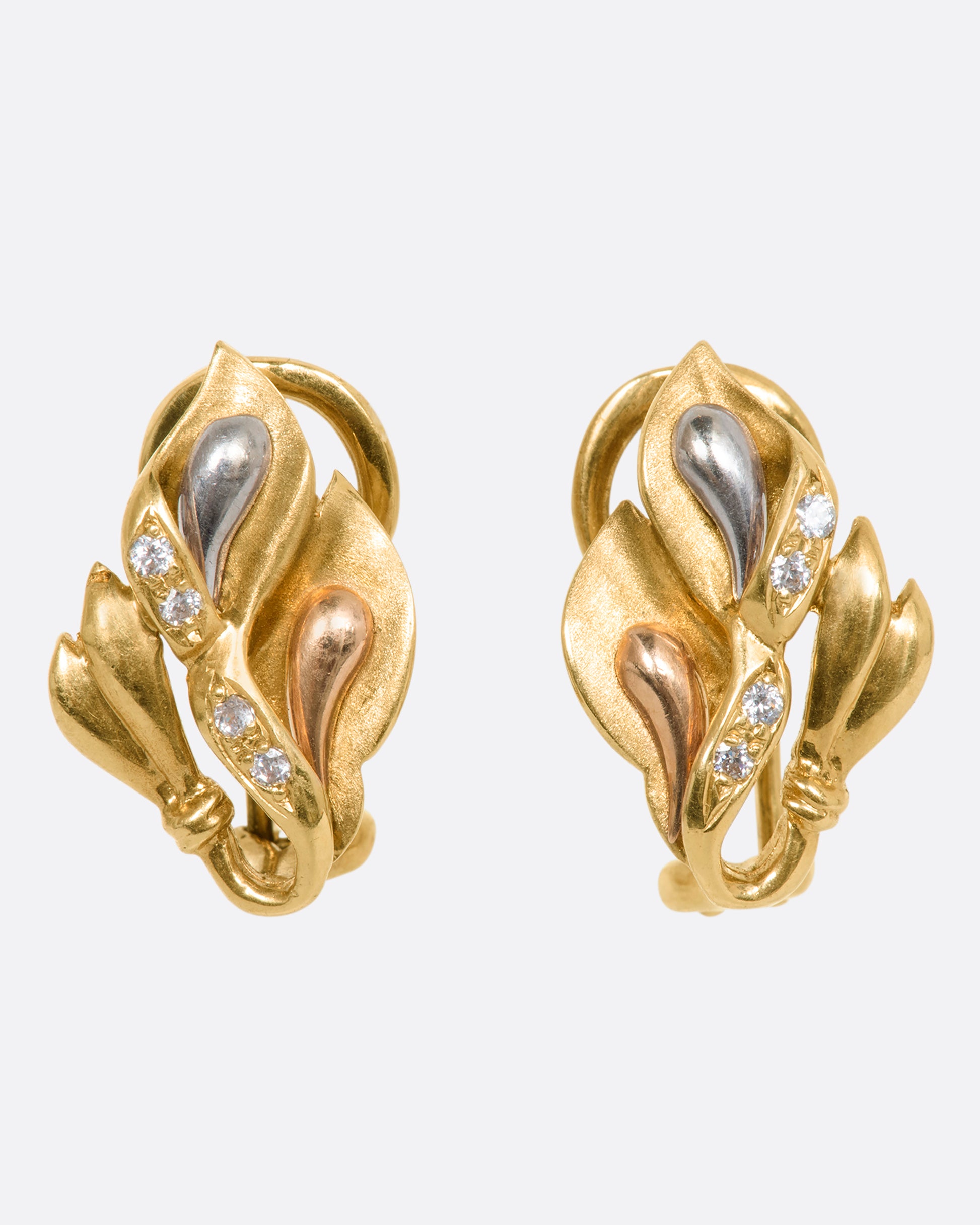 Tricolor leaf motif stud earrings with diamond details. View from the front.