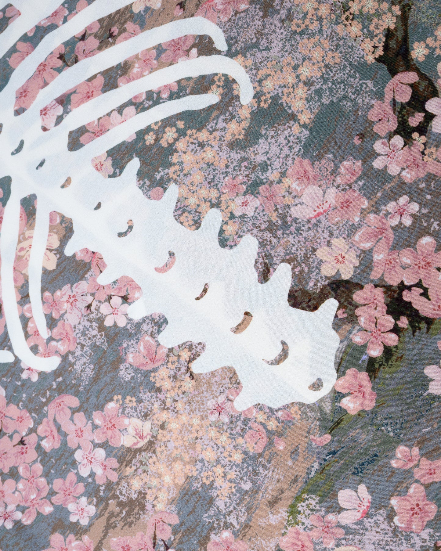 A close up of a button front short sleeve shirt with a cherry blossom print punctuated by Kapital’s skeleton motif, shown from the back.
