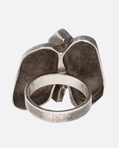 A silver abstract butterfly ring shown from the back.