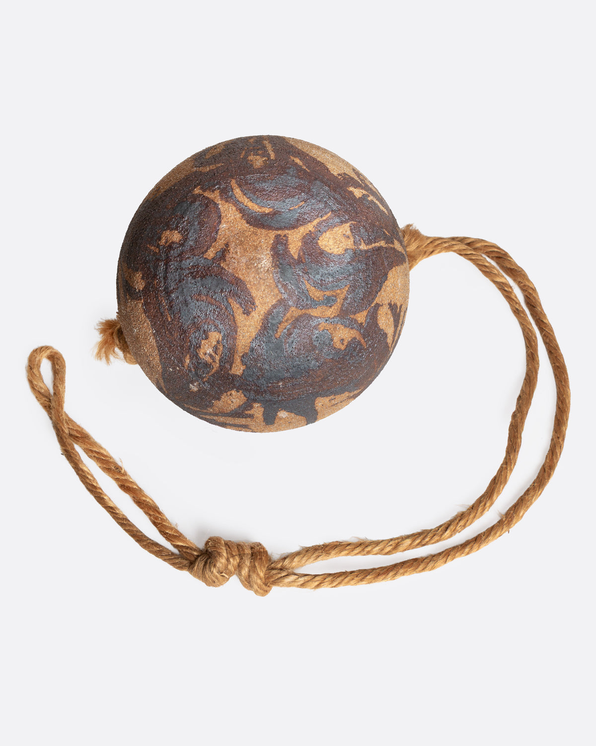 A ceramic pot with an abstract tan and brown pattern and cords for hanging, shown from the bottom.