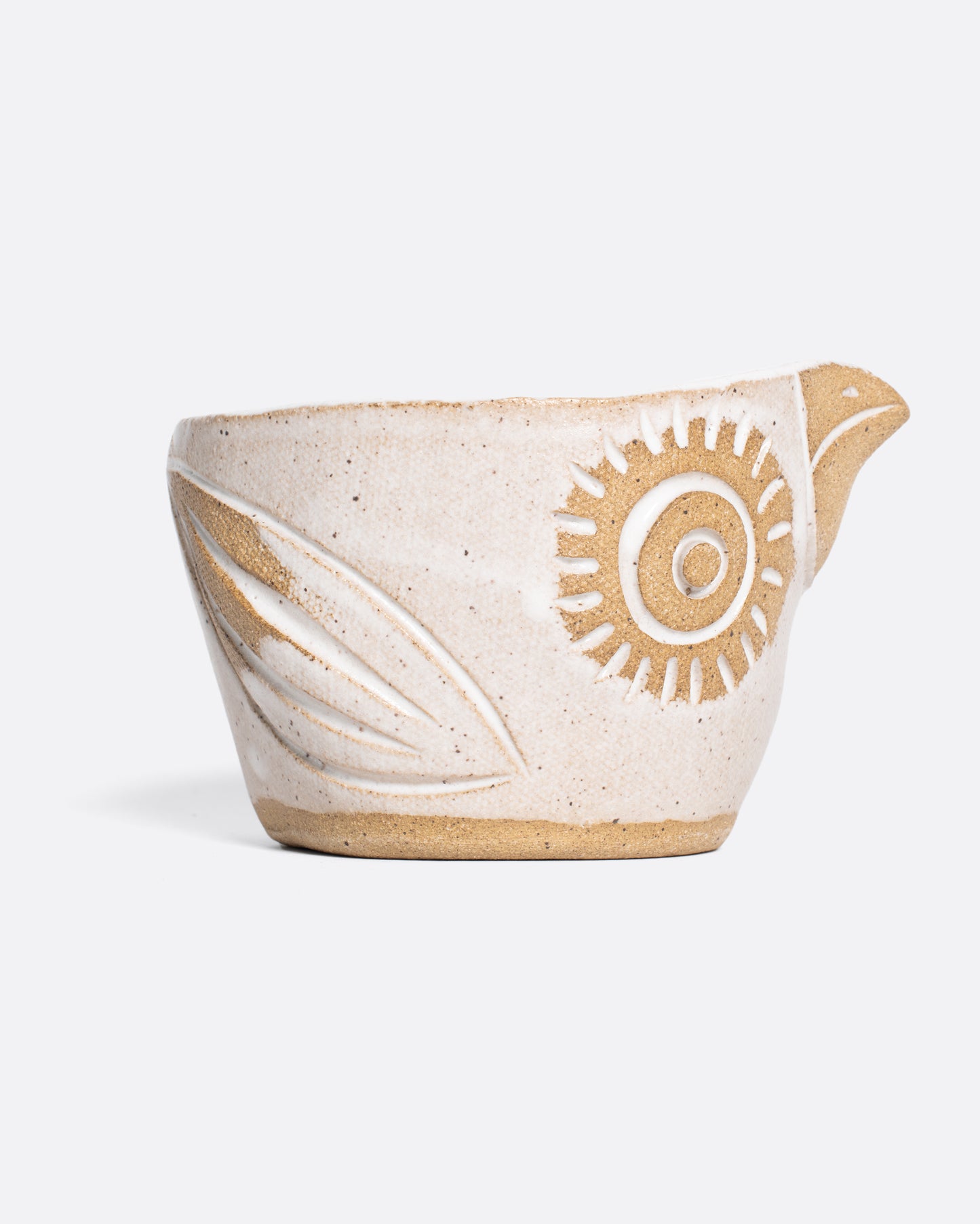 A handmade ceramic bird bowl whose beak serves as a spout, perfect for mixing and serving your favorite salad dressing.