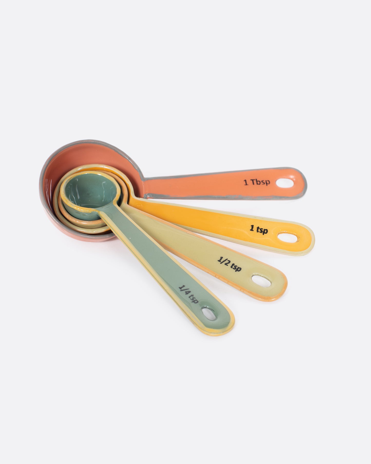 A set of four measuring spoons, each a different color.