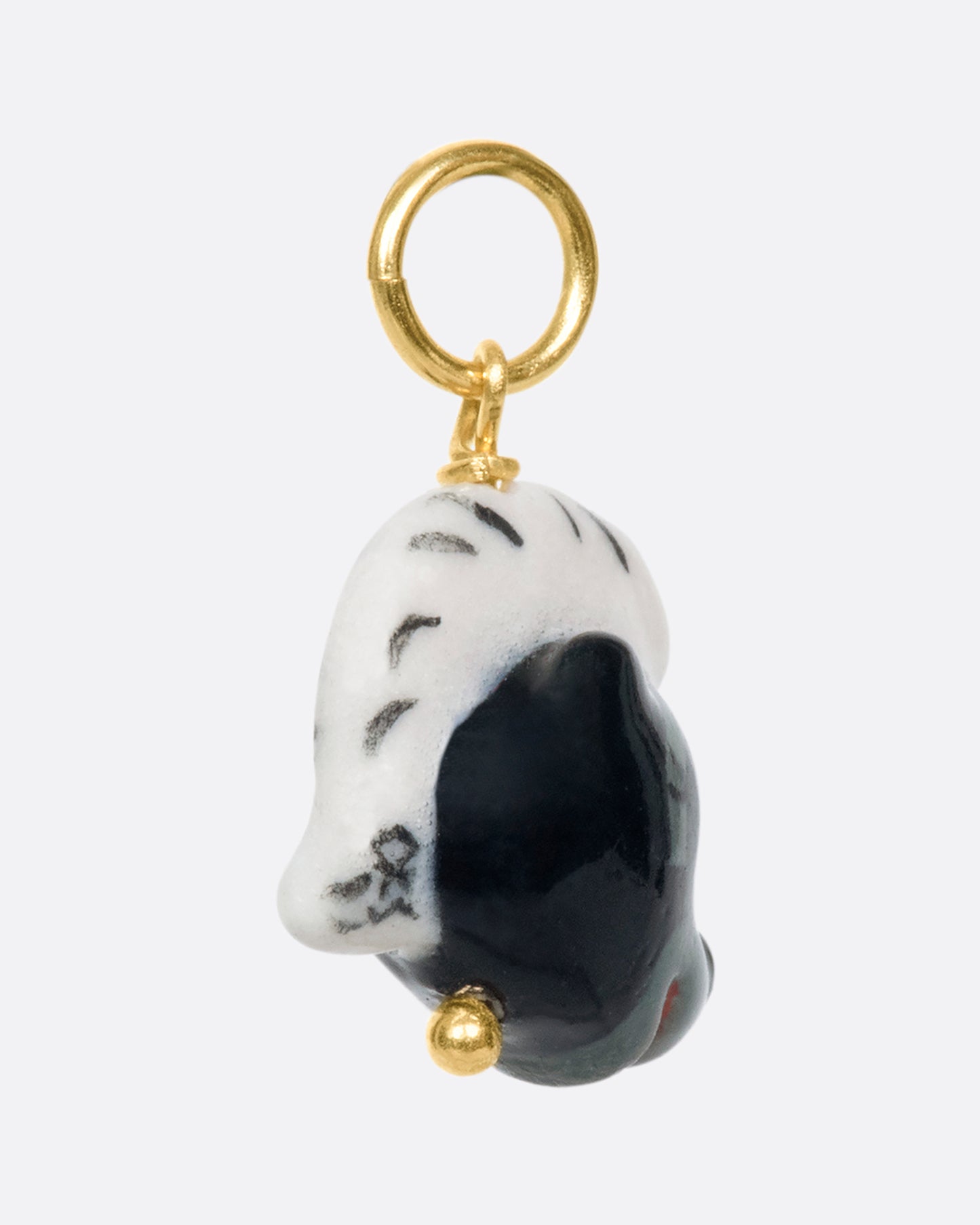 A handmade and painted porcelain Flower the Skunk charm with a 14k gold bail.