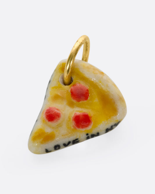 A handmade and painted porcelain pepperoni pizza slice charm with a 14K gold bail.