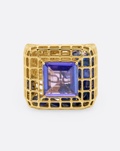 Sara Katherine Jacobson Cagey ring in yellow gold, a square tanzanite on an openwork cage filled with loose blue sapphires and diamonds