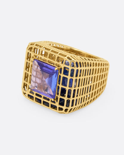 Yellow gold and tanzanite cage ring, side view with the tanzanite facing left and the tapered openwork shank