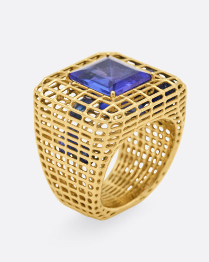 Yellow gold and tanzanite cage ring, angled view showing the tanzanite set high on the gold cage and openwork band