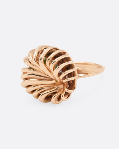 Rose gold swirl cage ring with emerald and tourmaline, side view from the other direction showing the twisted wires