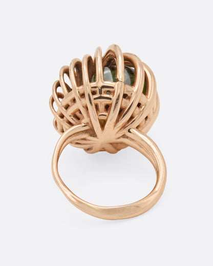 Rose gold swirl cage ring with emerald and tourmaline, back view of the band below the cage with green stones visible inside