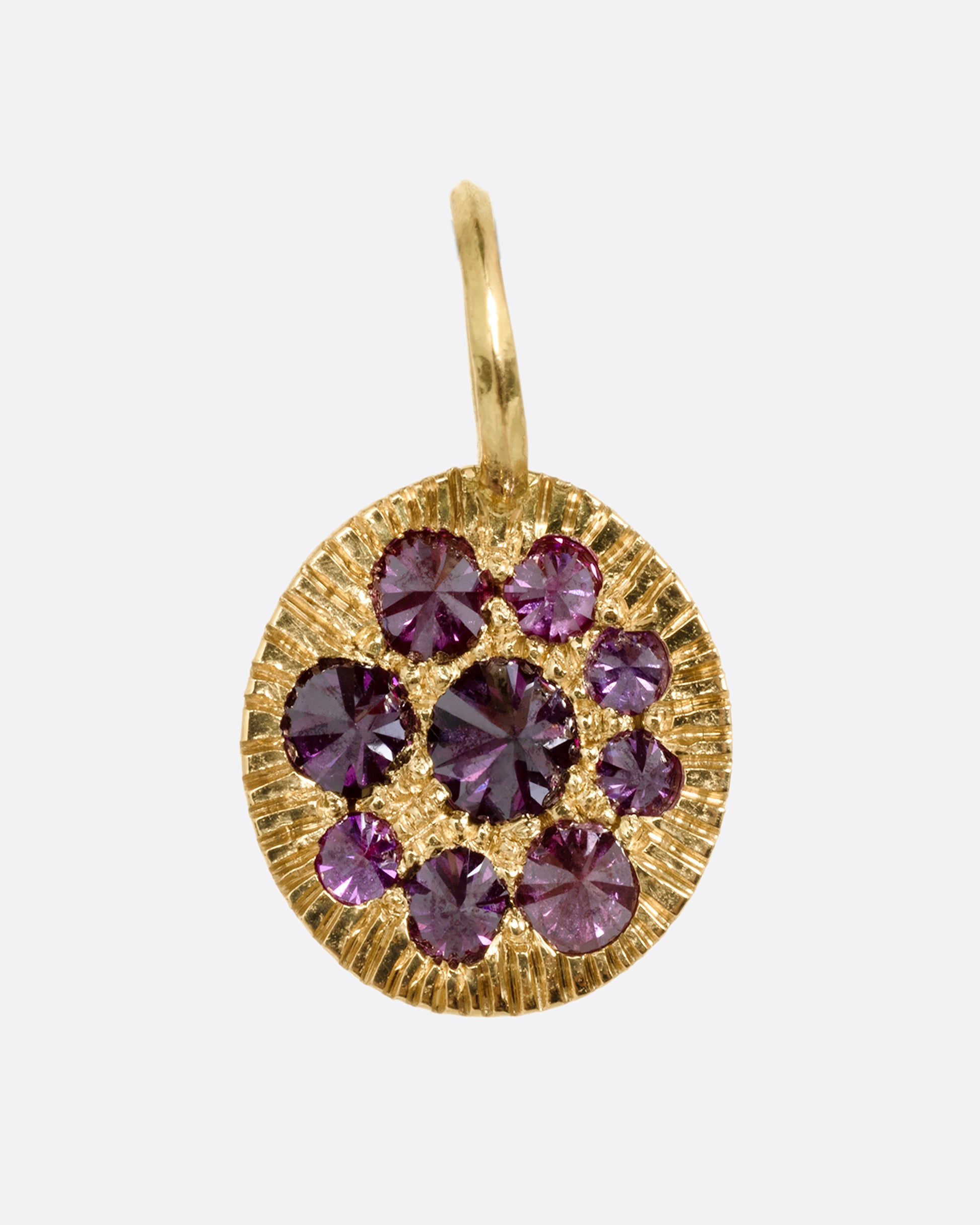 A yellow gold medallion with reverse set lavender diamonds, shown from the front.