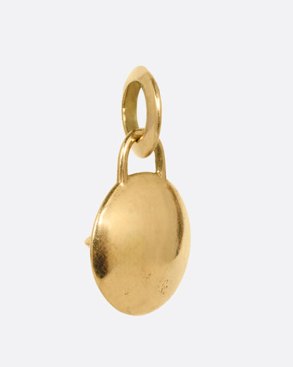 A round yellow gold pendant with a prong set opal, shown from the back.