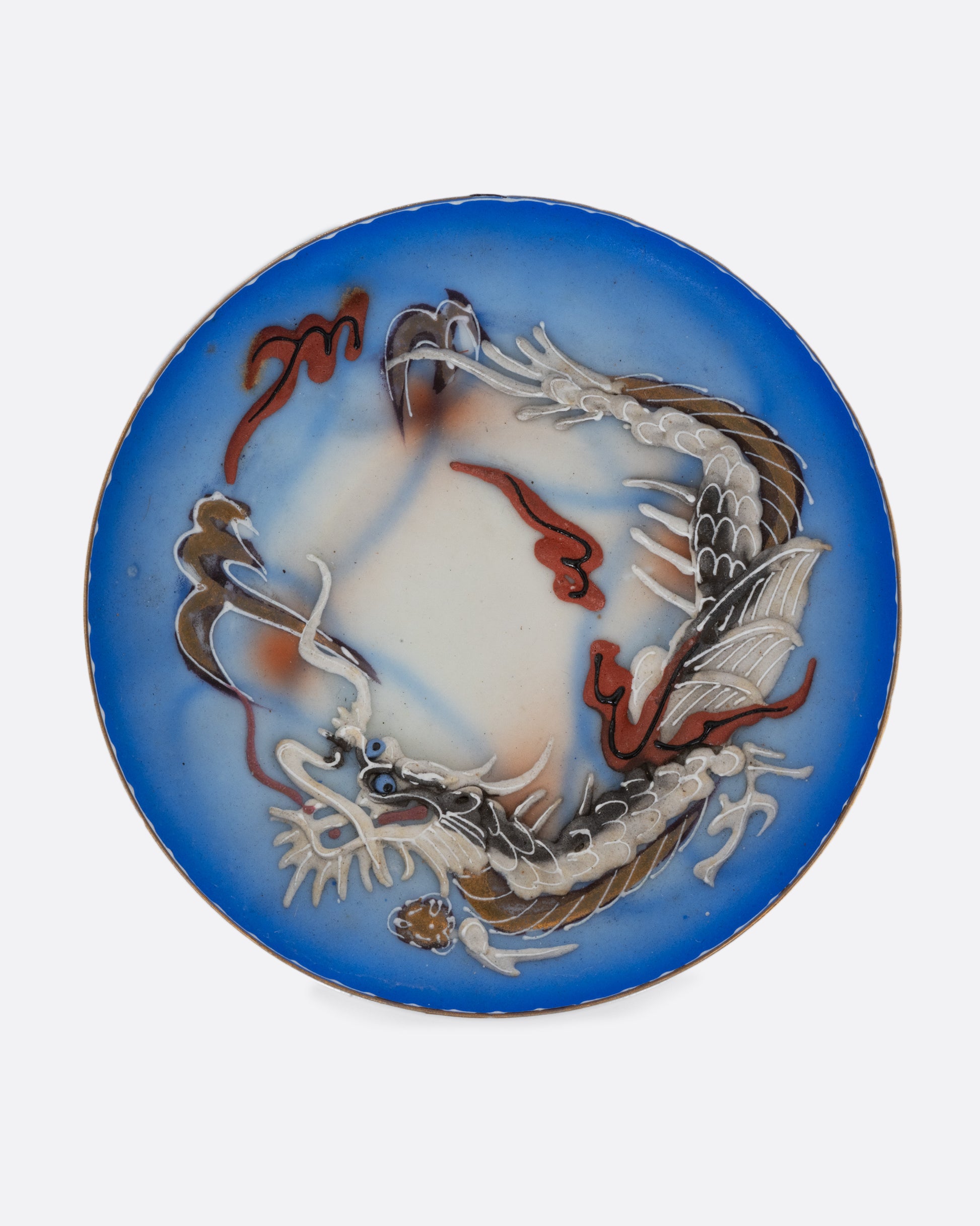 A dragonware moriage saucer with an enamel dragon motif in vibrant hues. Shown from the top.