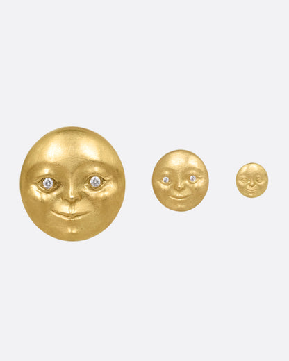 Three yellow gold moon face stud earrings with diamond eyes. Shown biggest to smallest from the front.