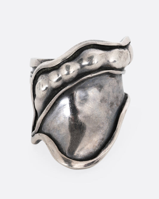 A silver leaf shaped wrap ring with silver drops along the top edge. Shown from the front.