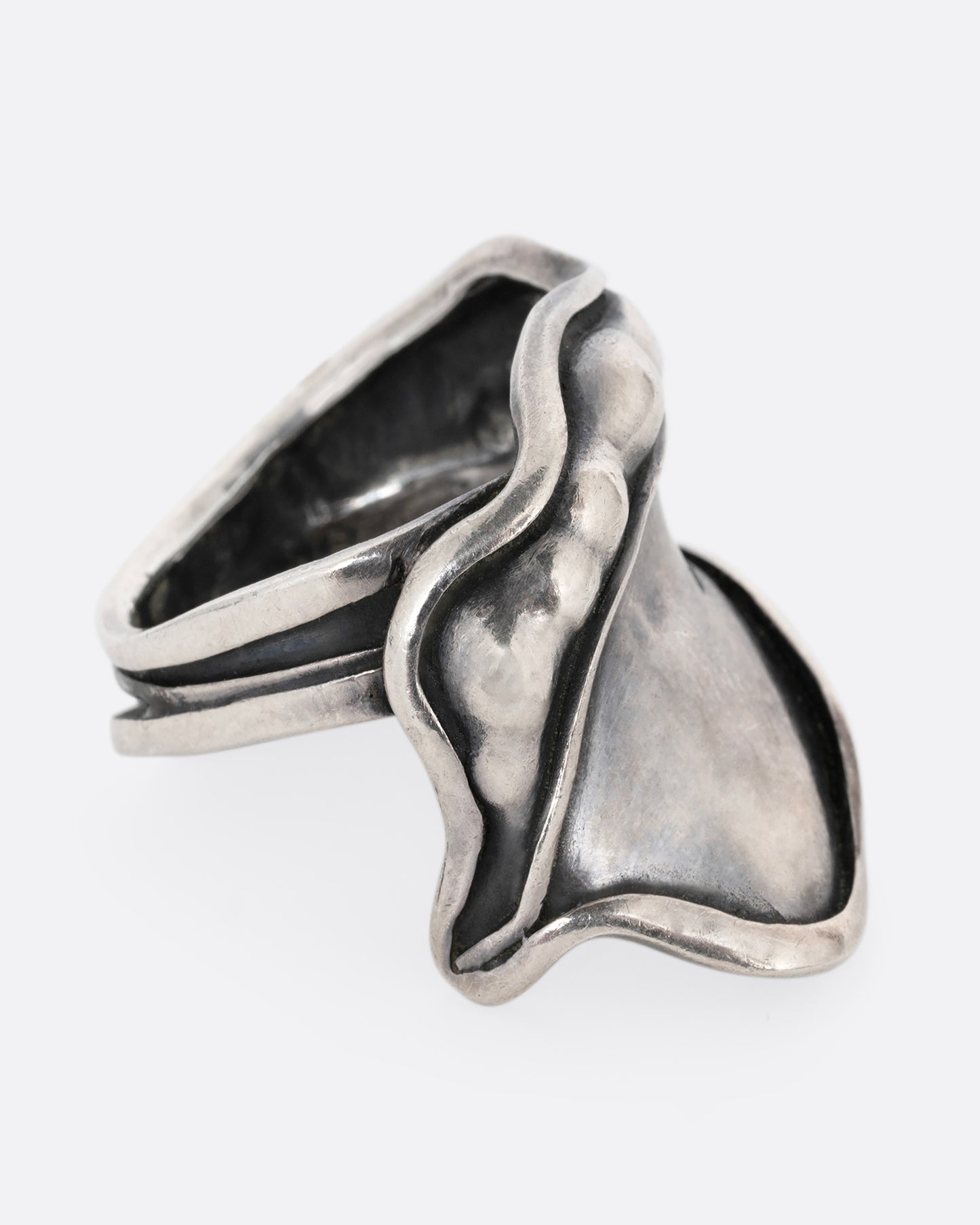 A silver leaf shaped wrap ring with silver drops along the top edge. Shown from the side.
