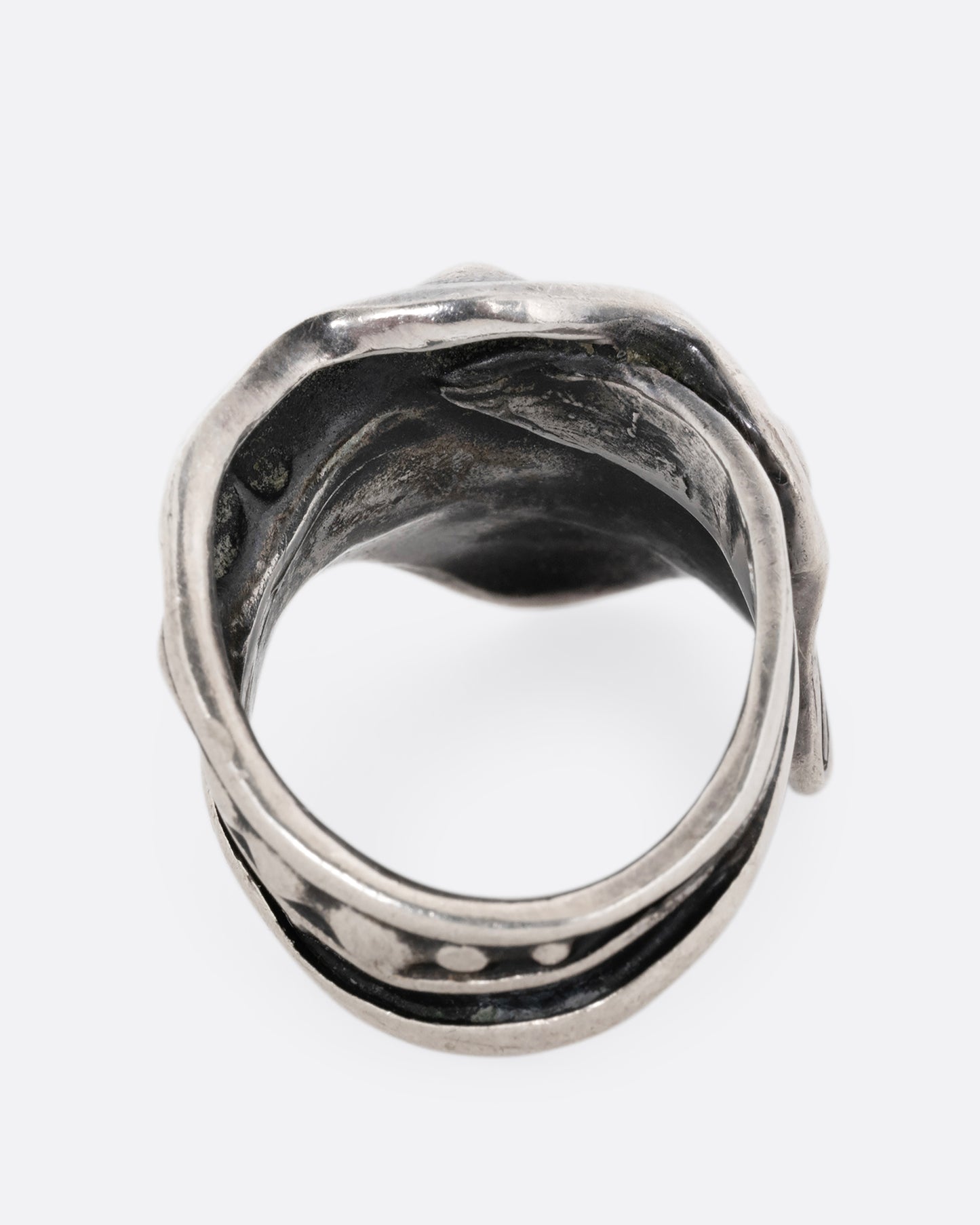 A silver leaf shaped wrap ring with silver drops along the top edge. Shown from the back.