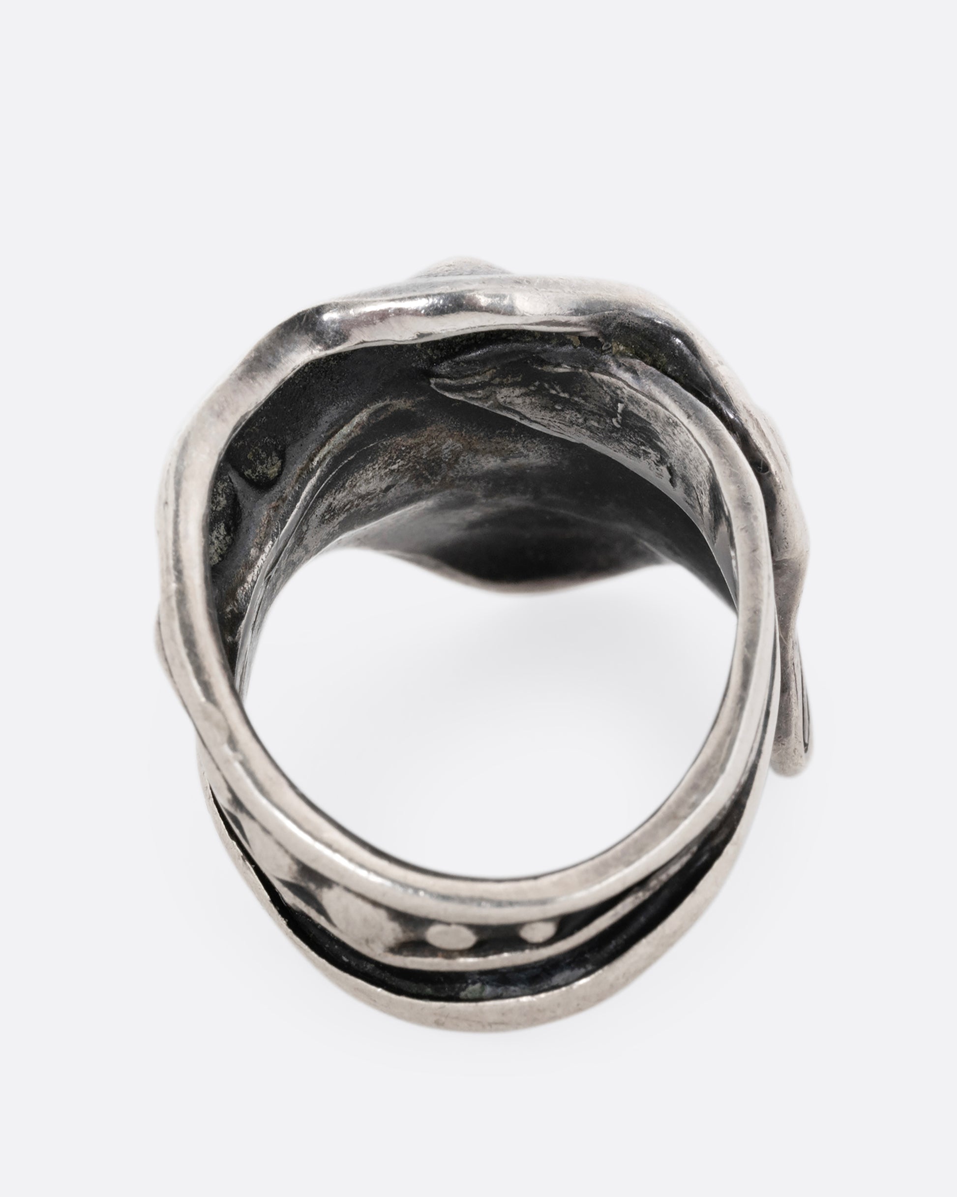 A silver leaf shaped wrap ring with silver drops along the top edge. Shown from the back.