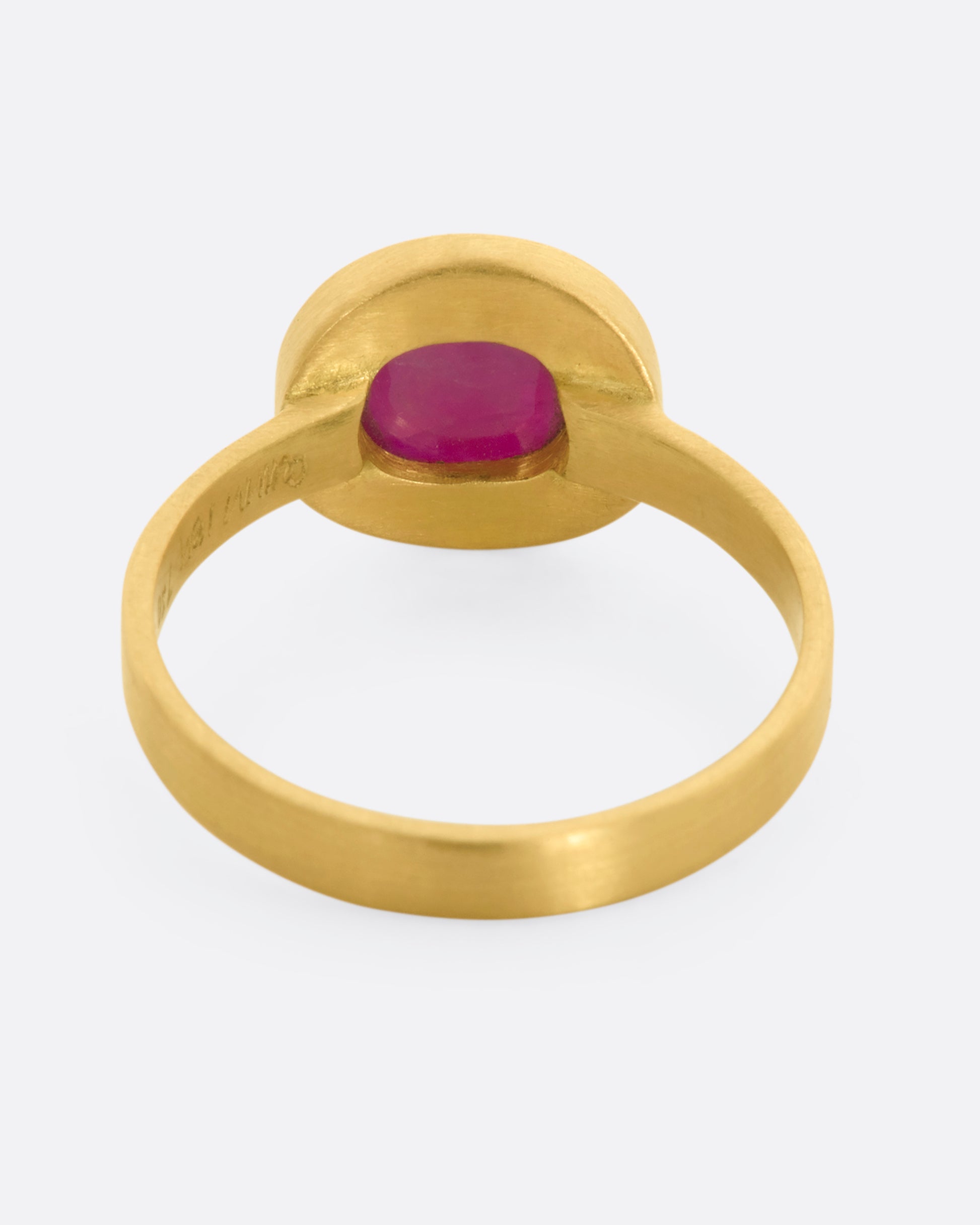 A yellow gold ring with a ruby cabochon. View from the back.