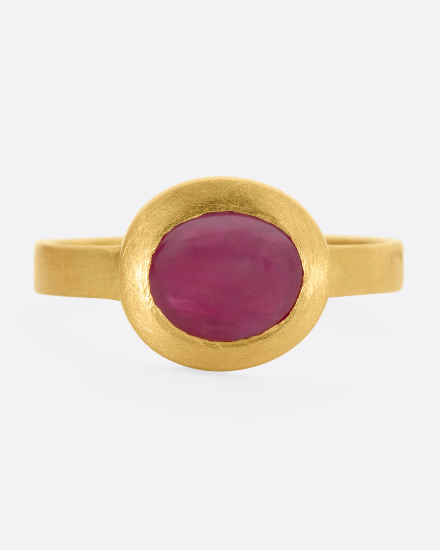 A yellow gold ring with a ruby cabochon. View from the front.