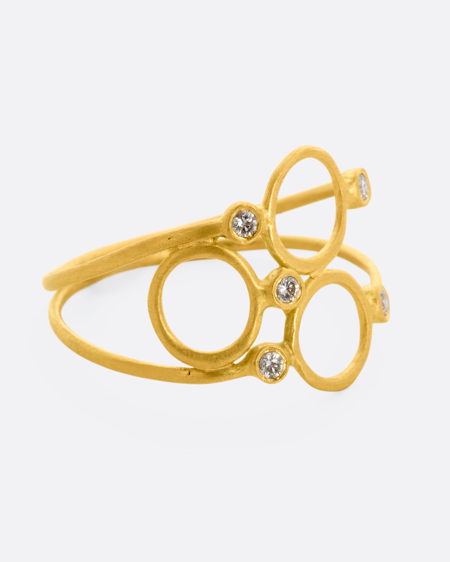 A yellow gold ring with three circles and five diamonds sandwiched between two thin bands. View from the alternate side.