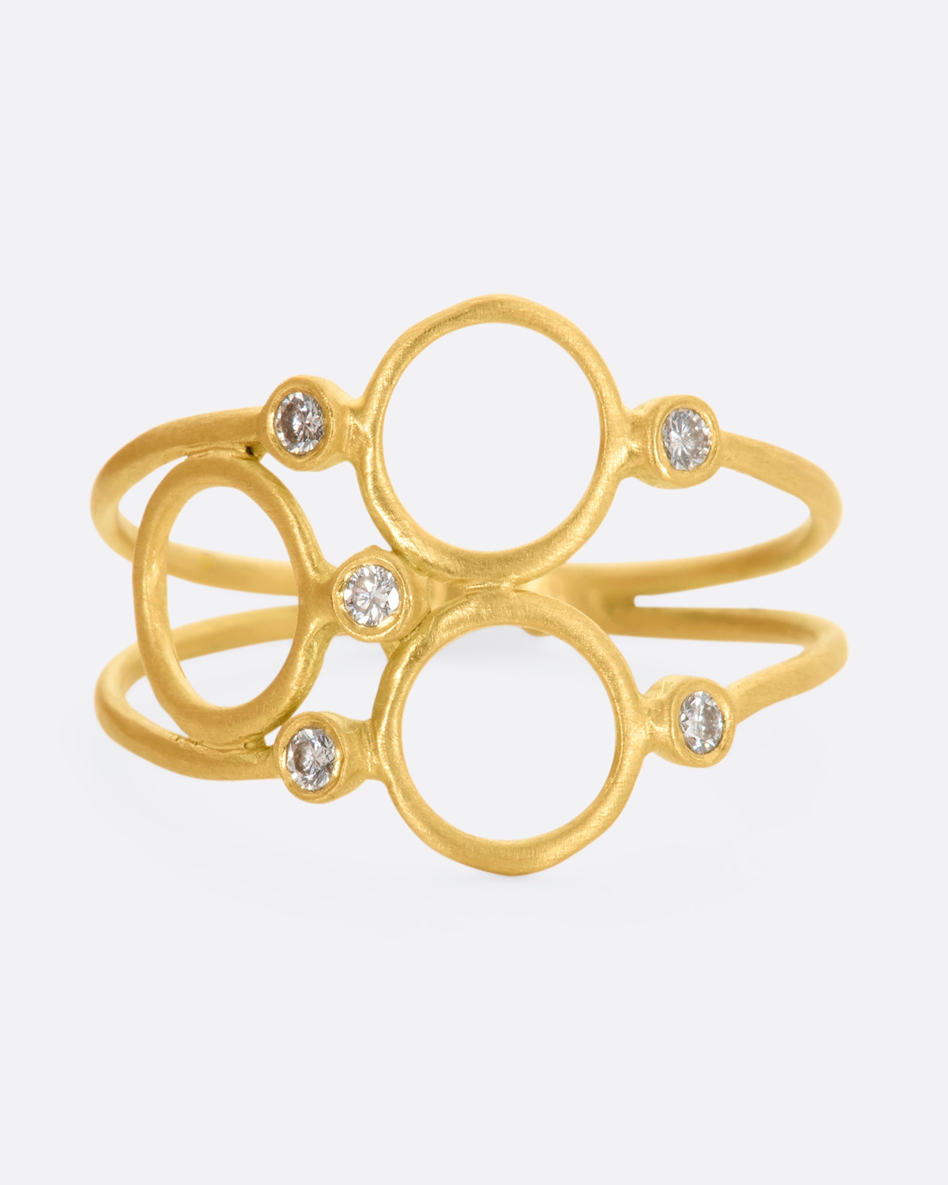 A yellow gold ring with three circles and five diamonds sandwiched between two thin bands. View from the front.