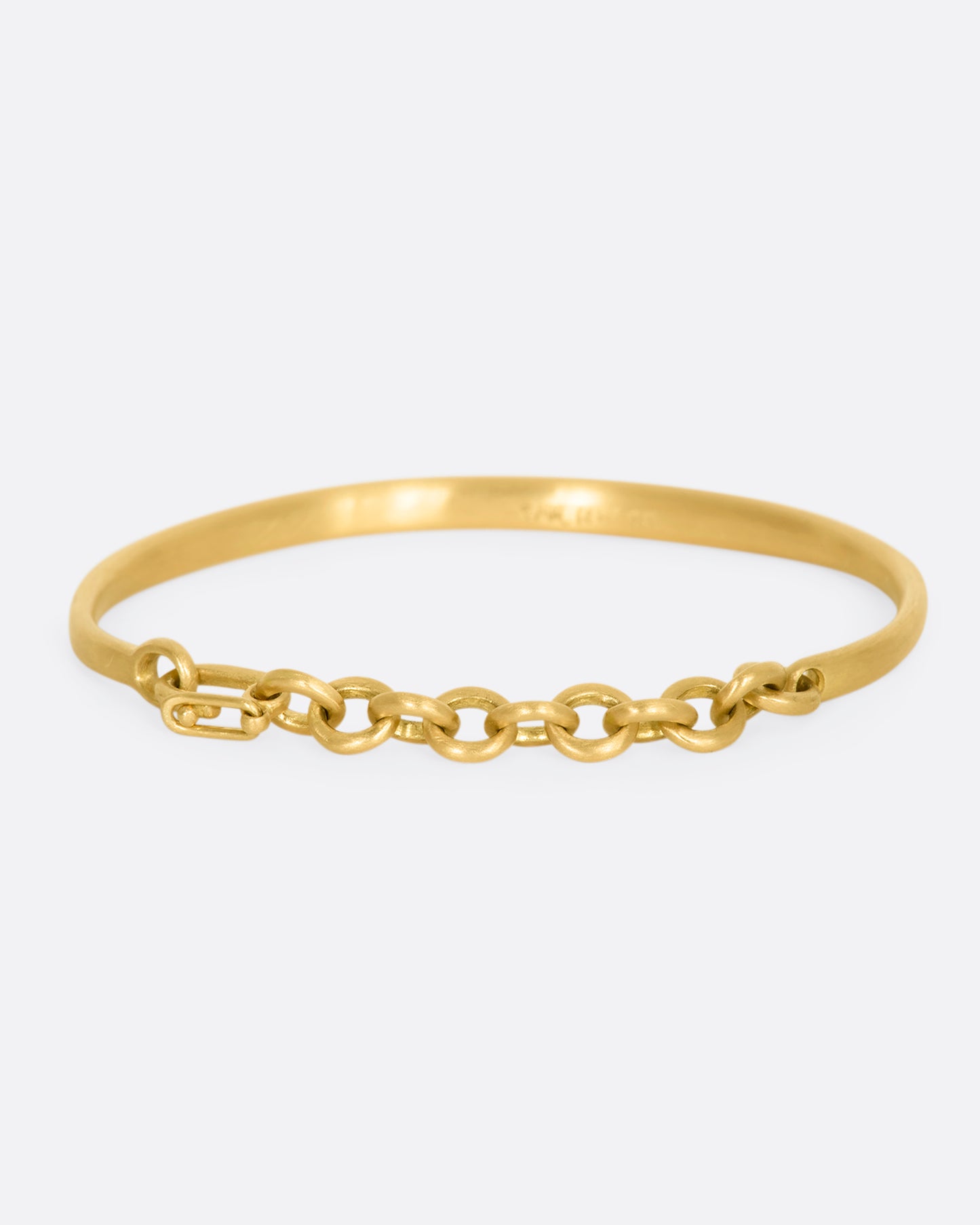 Yellow gold cuff bracelet with a chain closure.