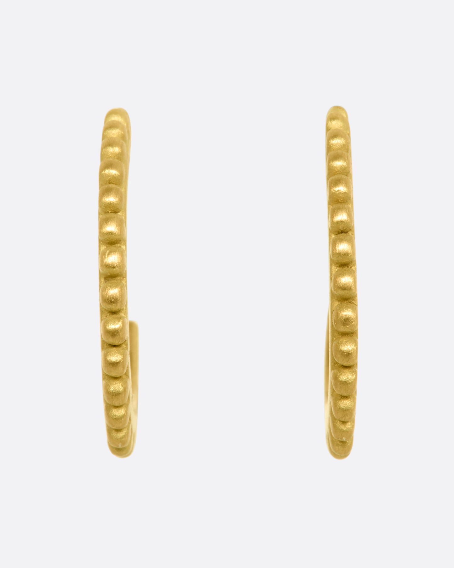 Yellow gold hoops with dotted detail around the edges. View from the front.