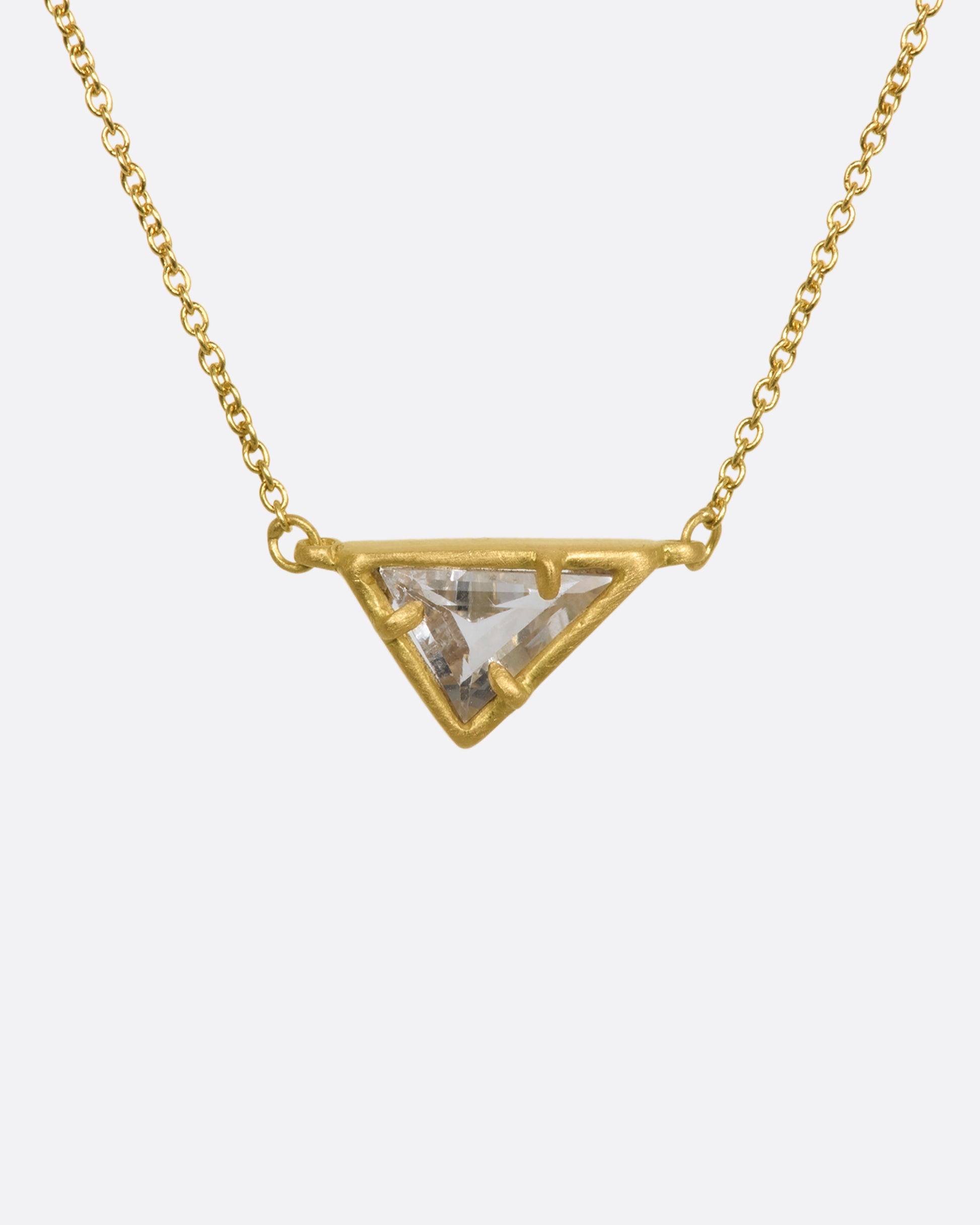 A yellow gold necklace with a triangular goshenite pendant. View from the front.