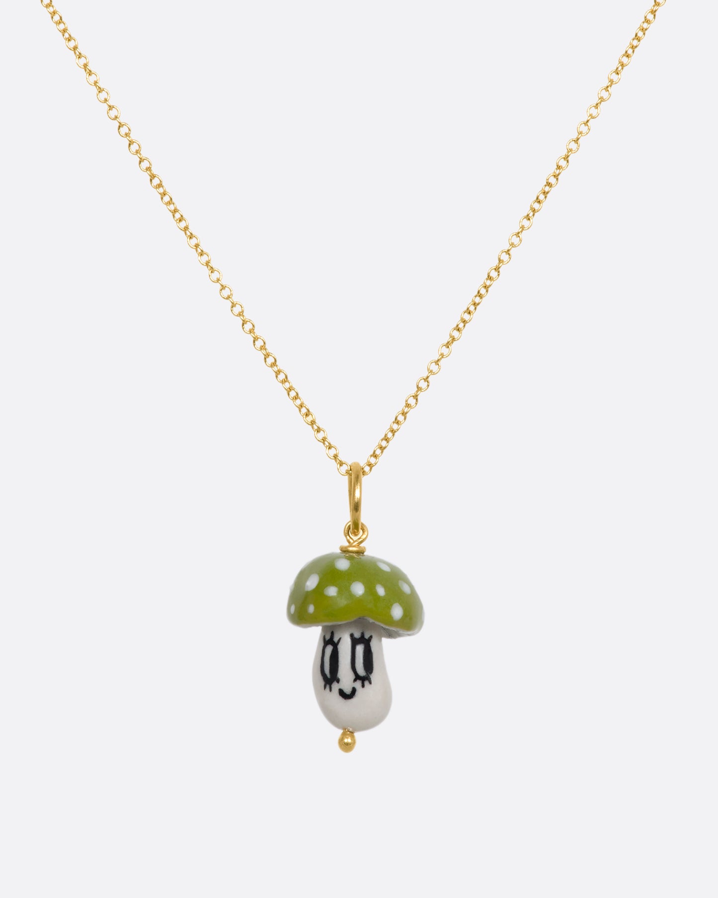 Green mushroom charm on a yellow gold bail. Hanging from a chain.