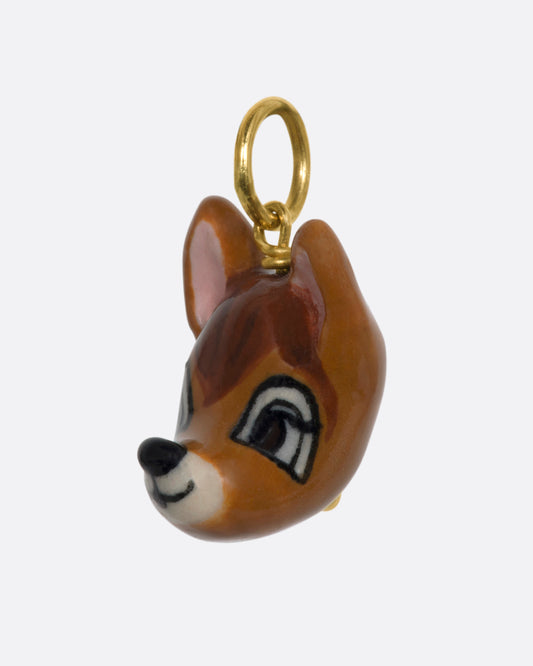 A hand painted 3D porcelain Bambi charm with a yellow gold bail. View from the side.