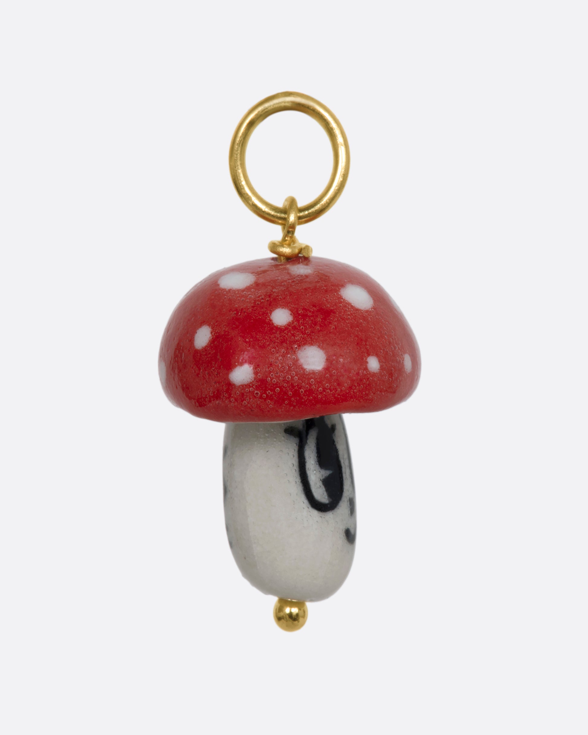 Red mushroom charm on a yellow gold bail. View from the side.