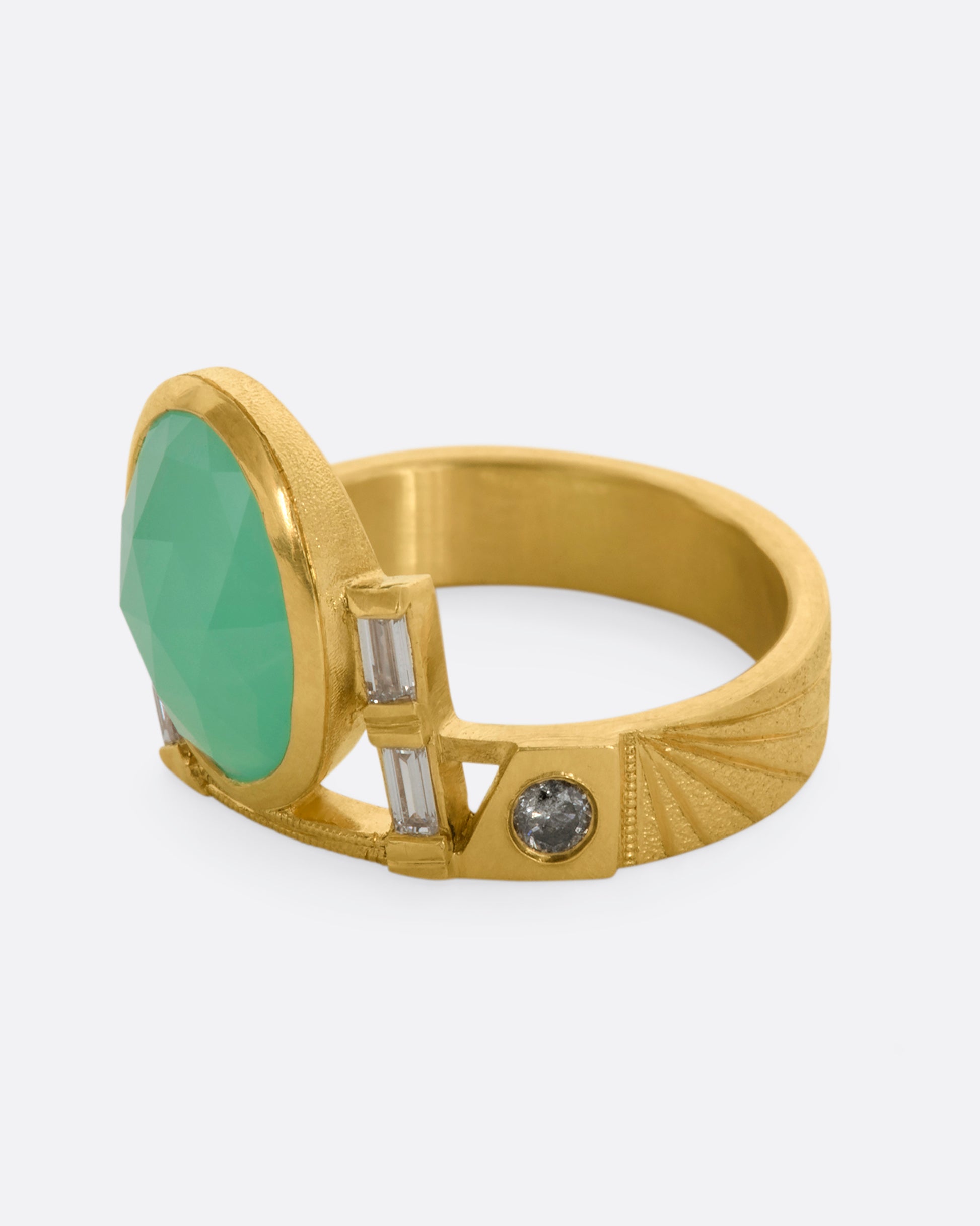 A yellow gold wide band ring with an oval chrysoprase, stacked baguette and round diamonds. View from the alternate side.