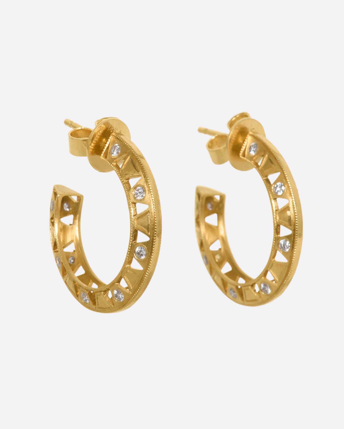 Intricate yellow gold hoop earrings with diamonds. View from the side.