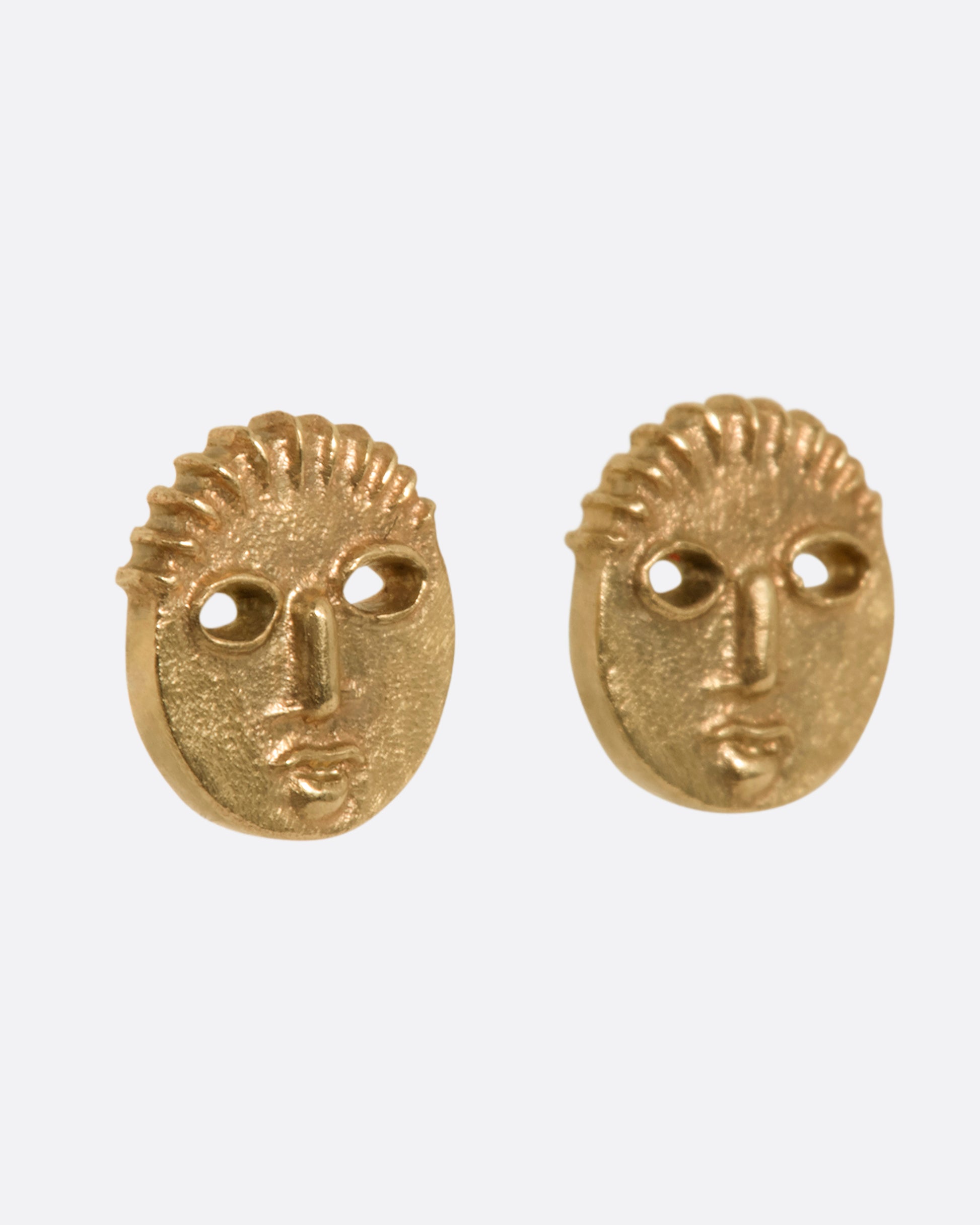 Yellow gold mask stud earrings. View from the side.