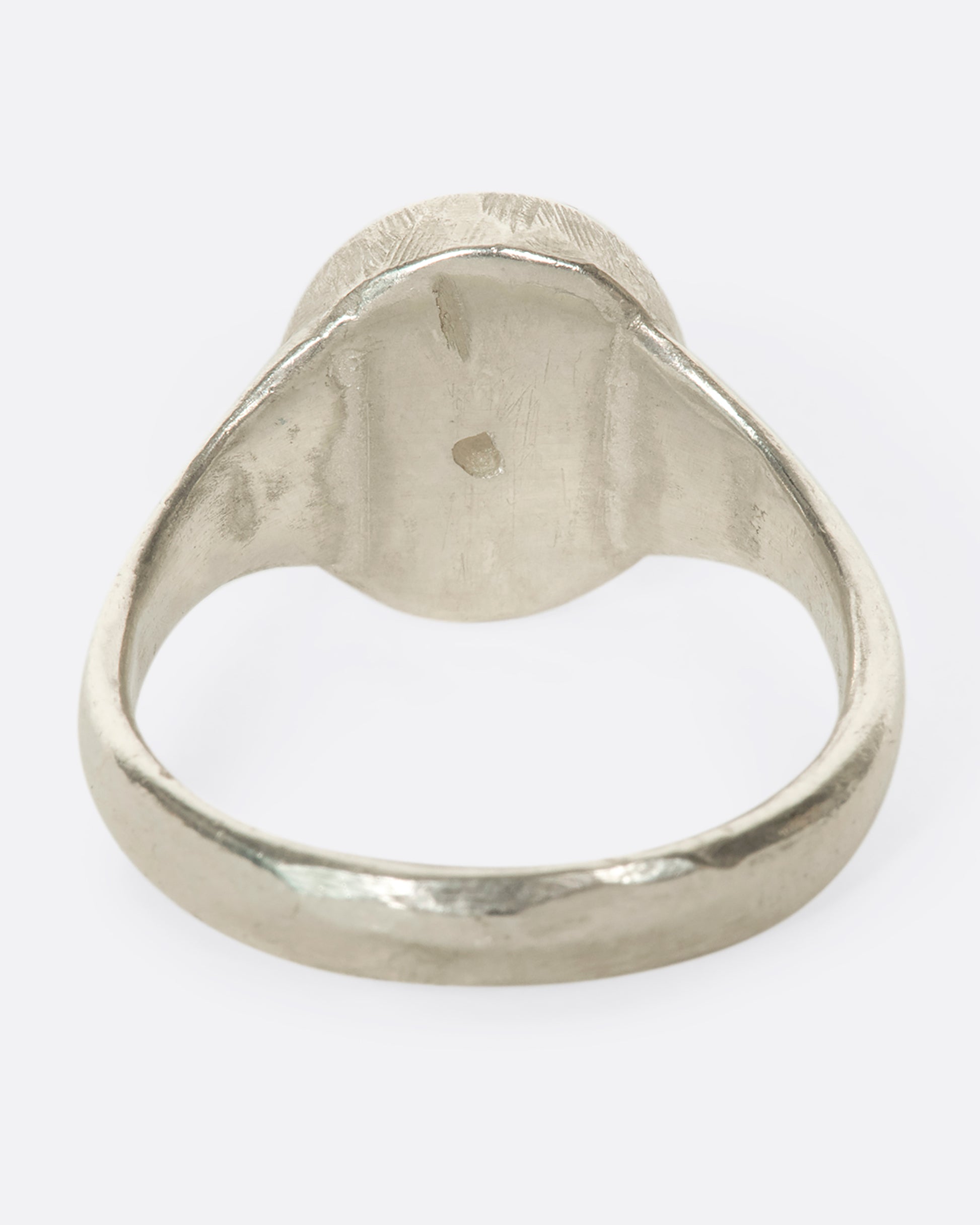 A sterling silver signet ring with a pear-shaped salt and pepper diamond secured with tiny prongs