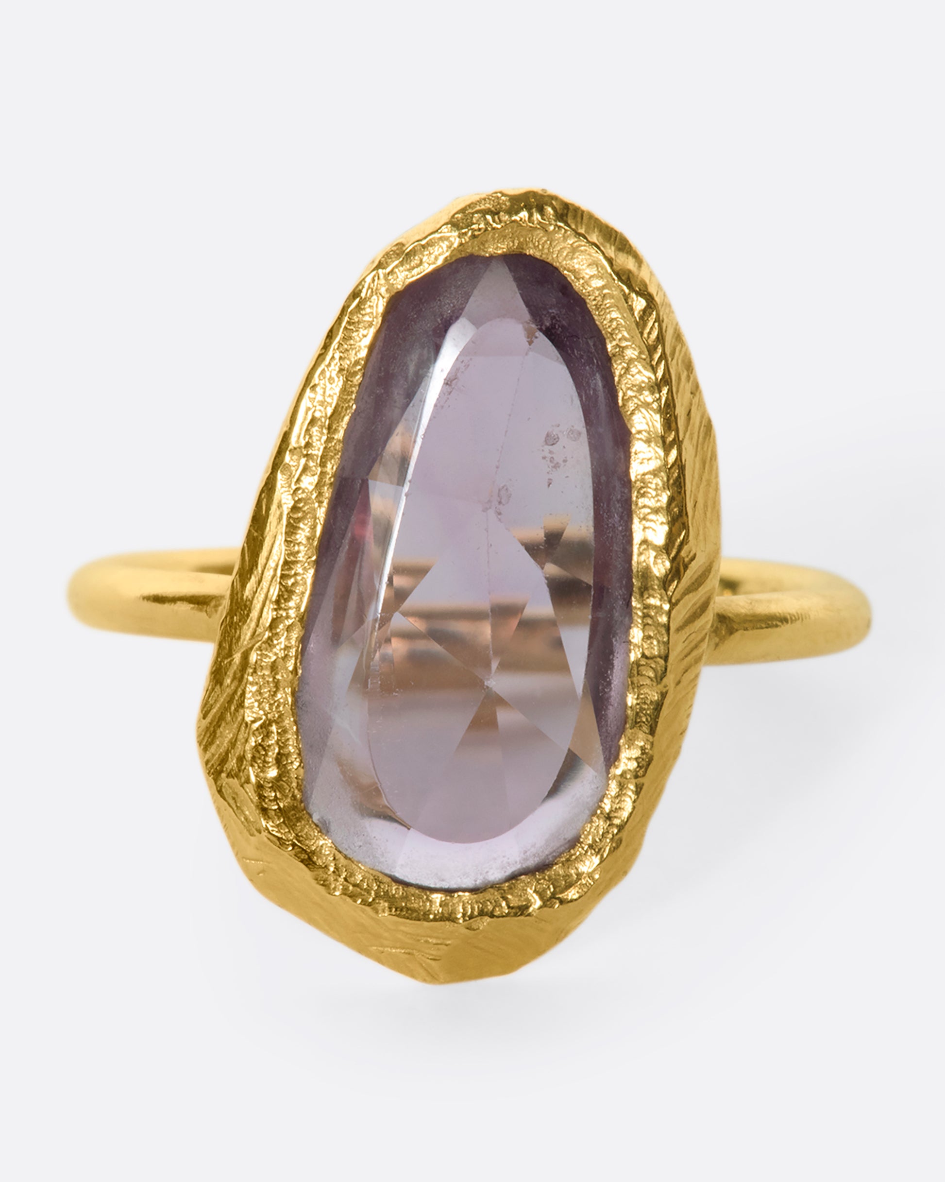 This truly unique freeform, rose-cut purple sapphire is nestled in a hand-carved 18k gold bezel setting