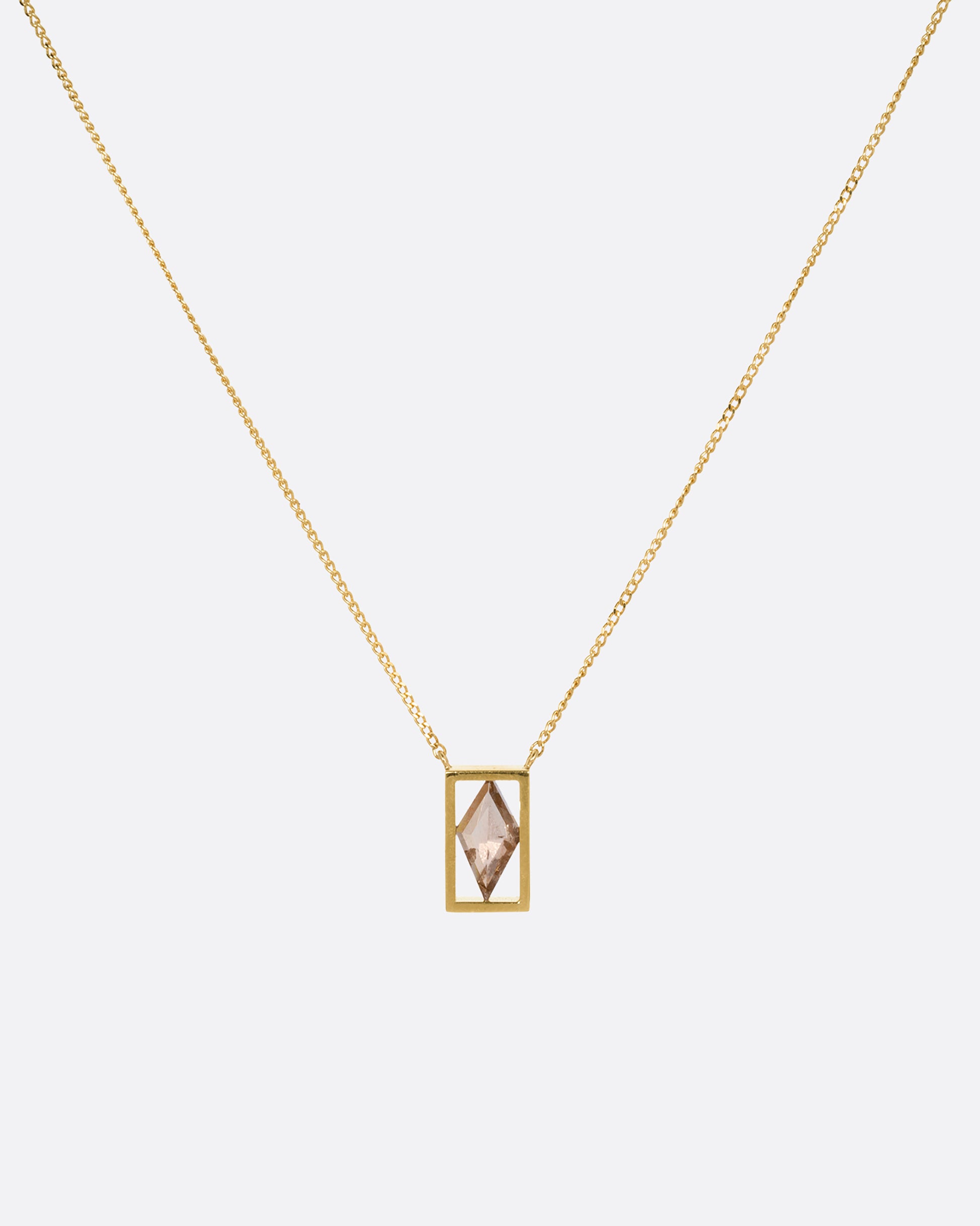 A yellow gold cable chain necklace with a rhombus shaped diamond in an open rectangular setting, shown from the front.