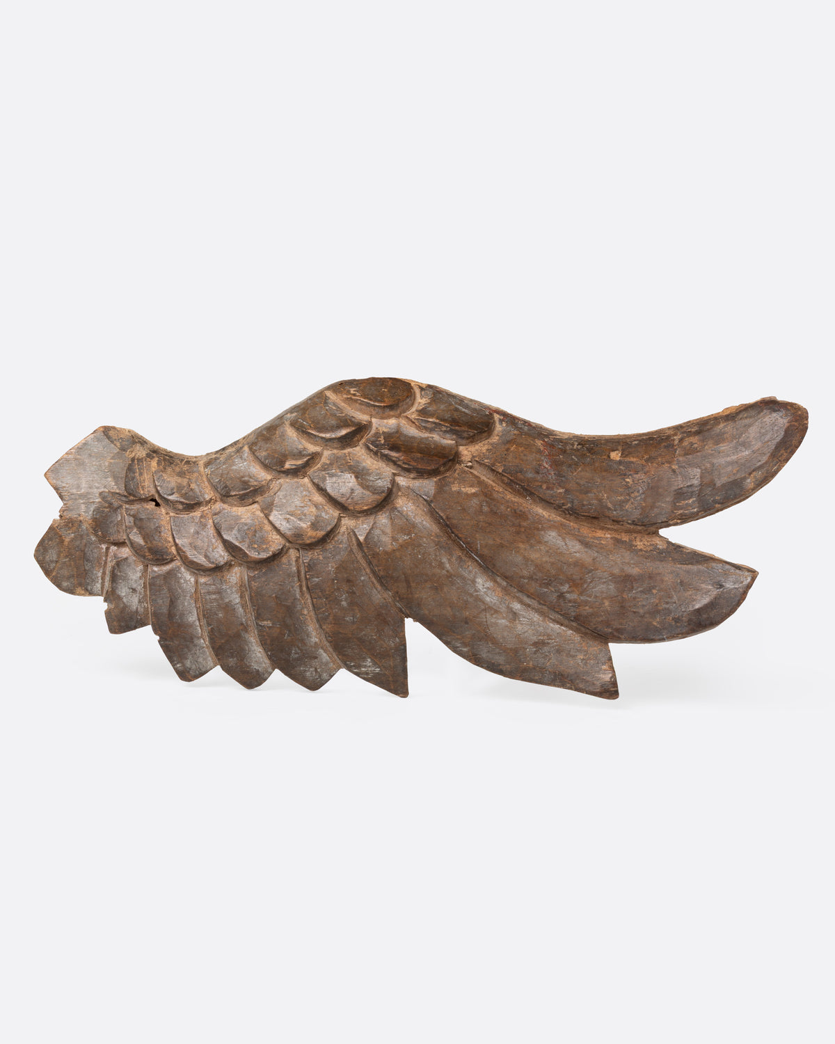 A wooden hand carved wing, shown from the side.