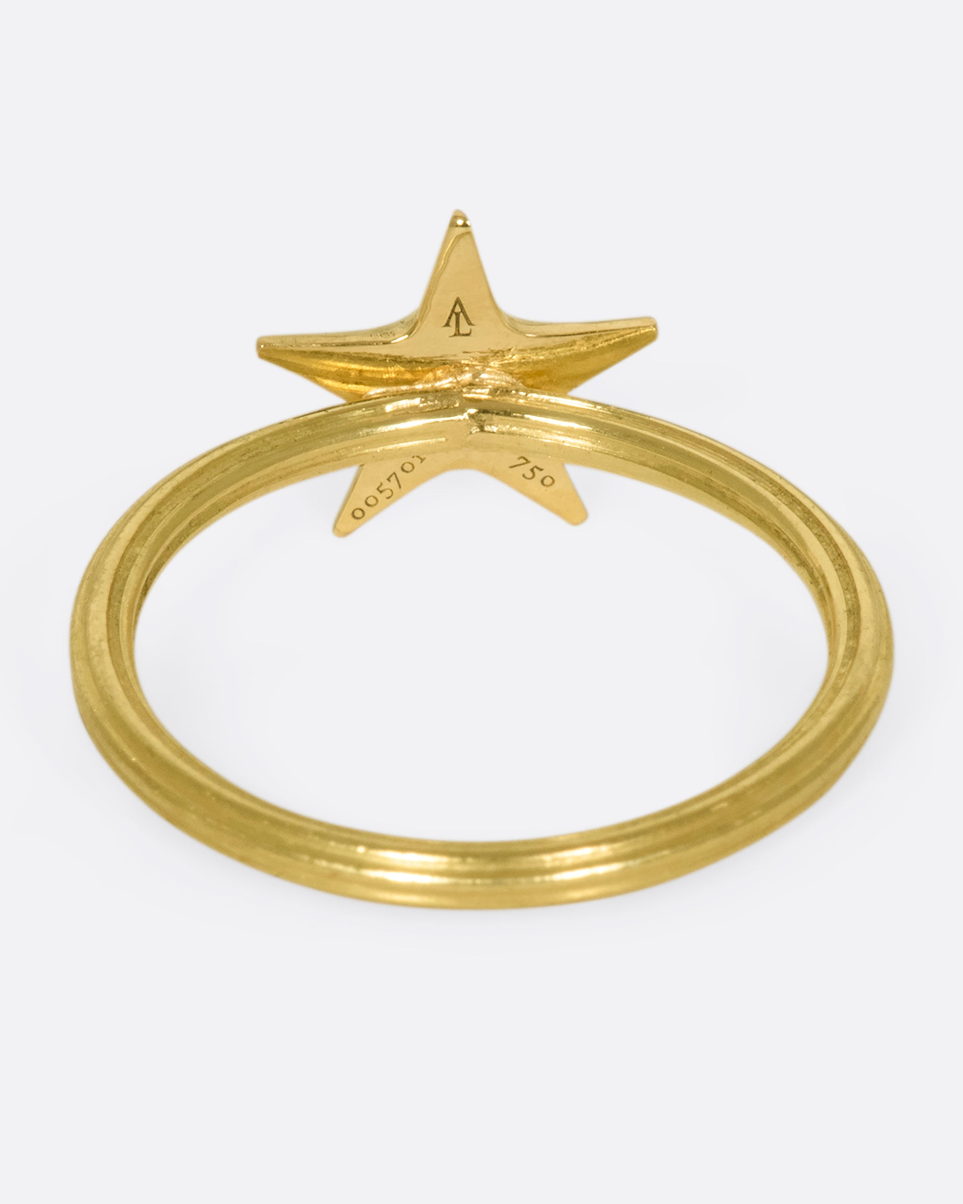 An 18k gold star ring with a sweet face emerging in the center.