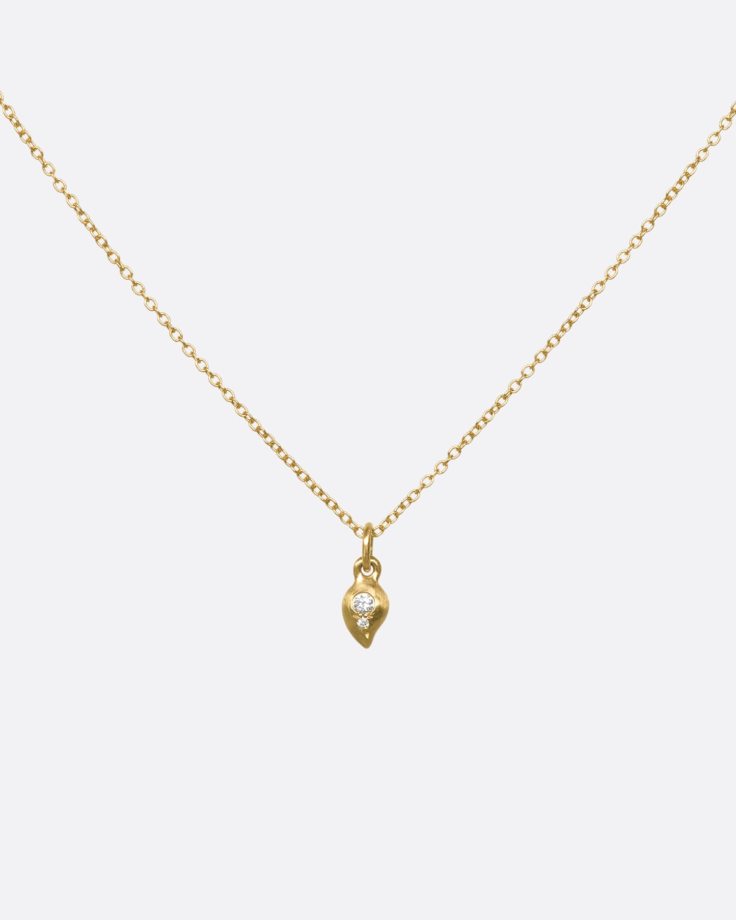 This delicate 10k gold necklace features two diamonds sparkling in a gold droplet