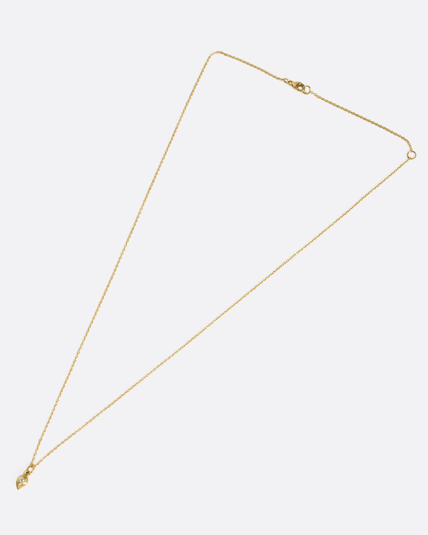 This delicate 10k gold necklace features two diamonds sparkling in a gold droplet