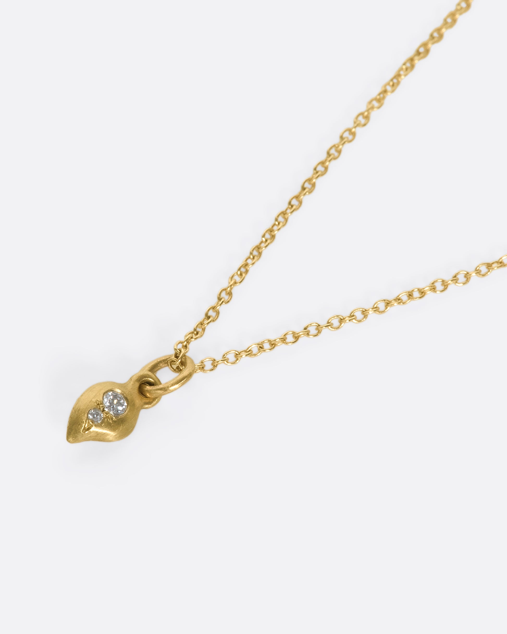 This delicate 10k gold necklace features two diamonds sparkling in a gold droplet