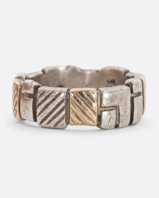 A textured sterling silver and yellow gold band with squares all around.