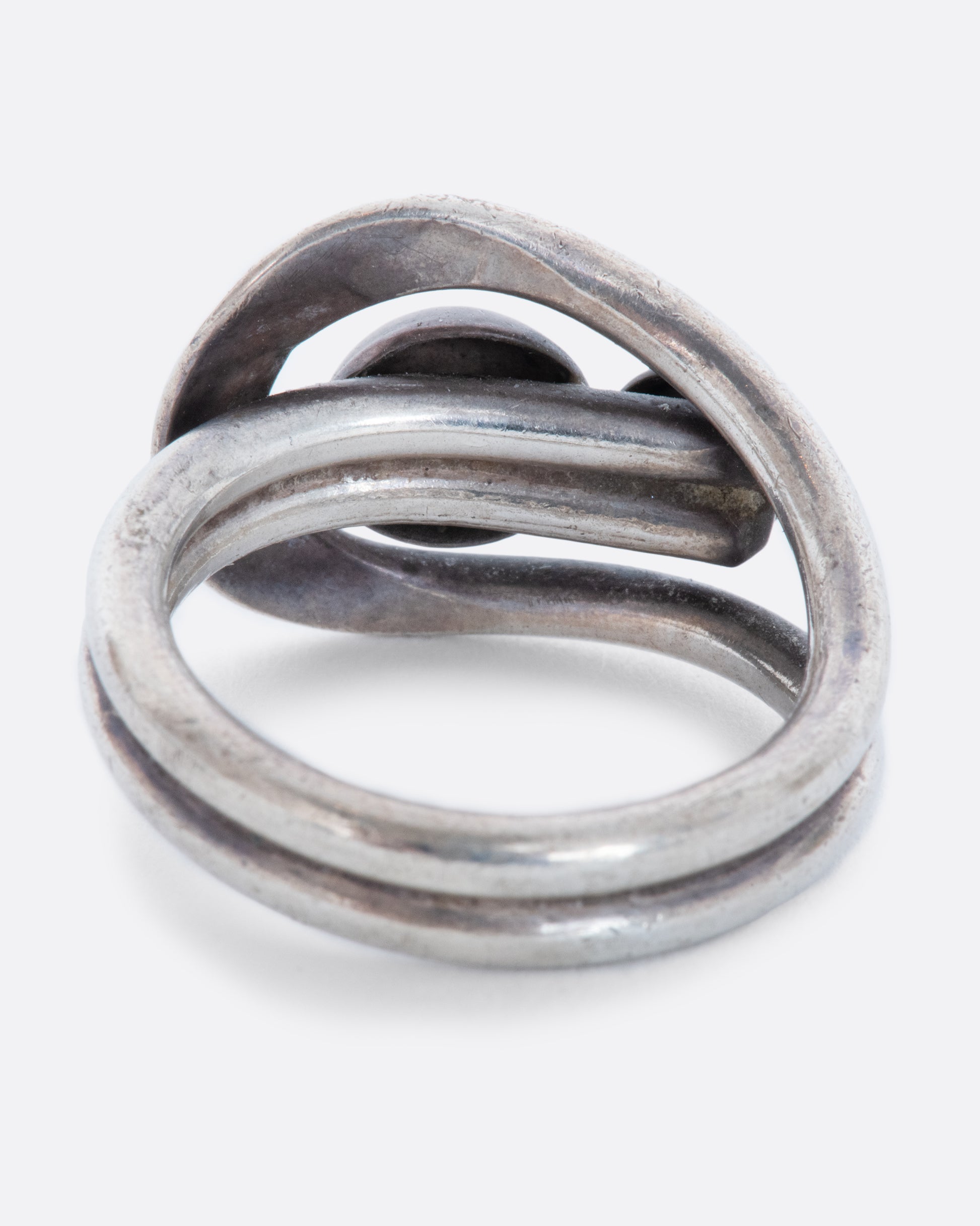 A sterling silver wrap ring with two spheres at the center. Shown from the back.