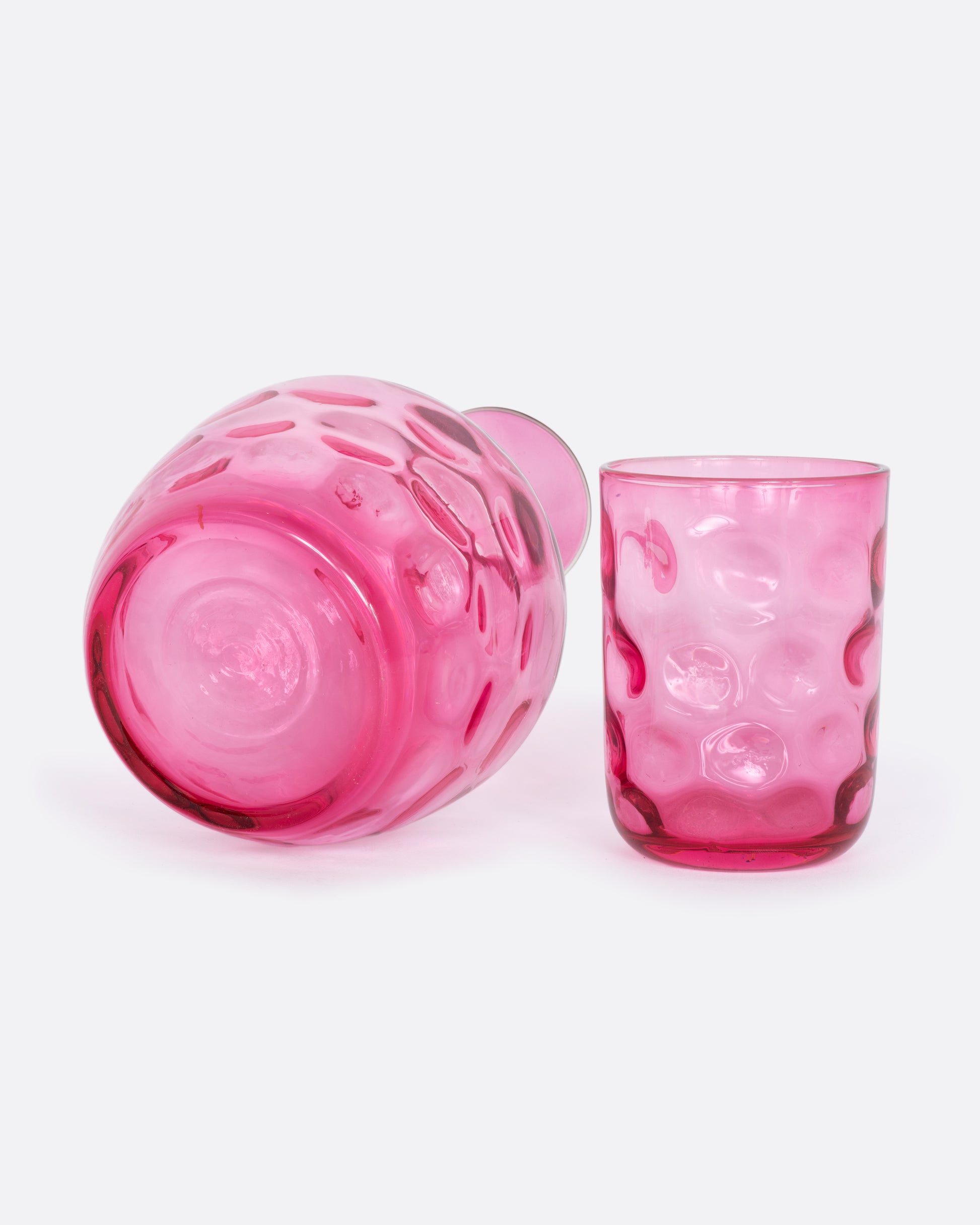 Pink dimpled glass decanter and cup set. View underneath the decanter.