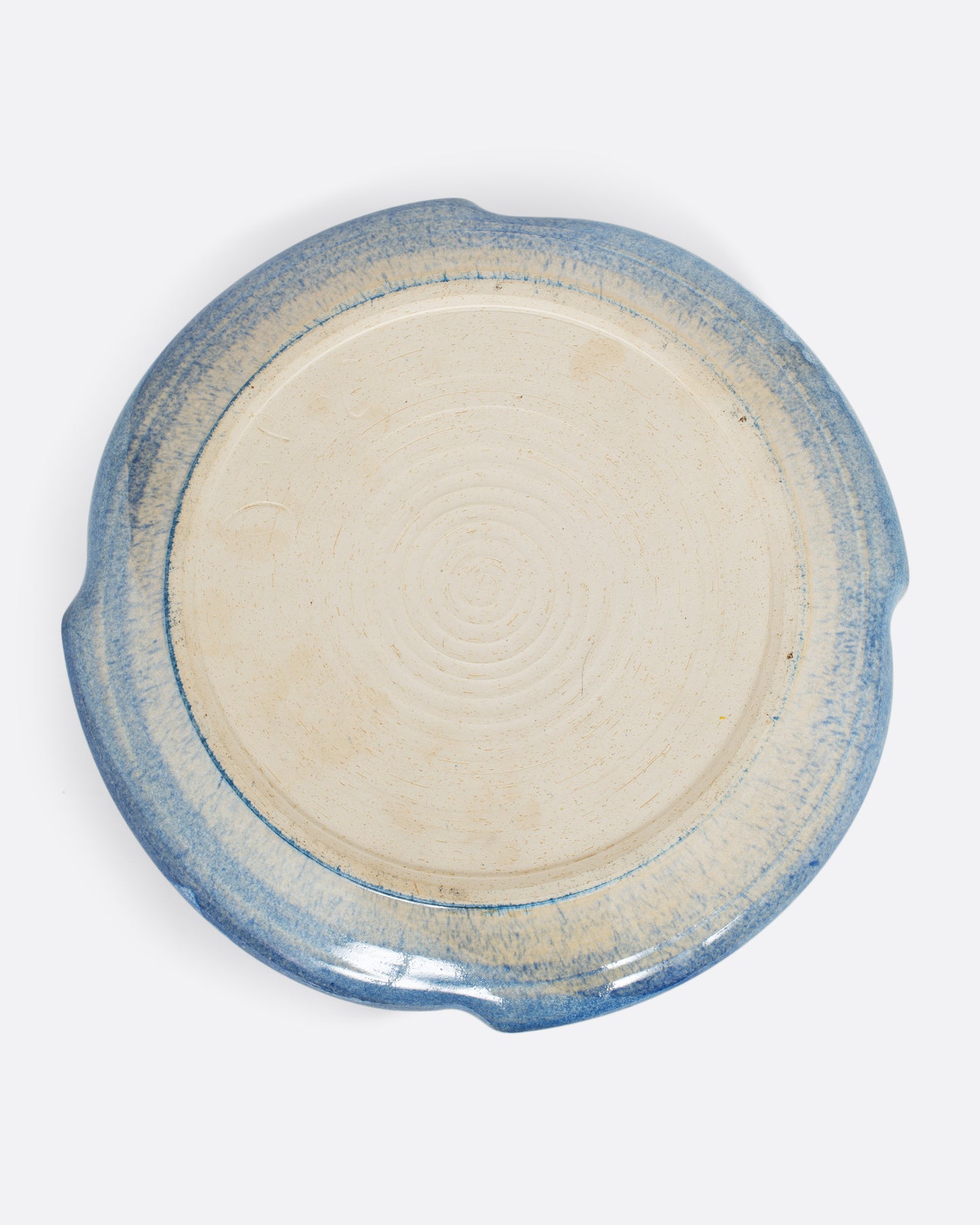 A ceramic chip and dip plate with a blue edge on its reverse. Shown from the bottom.