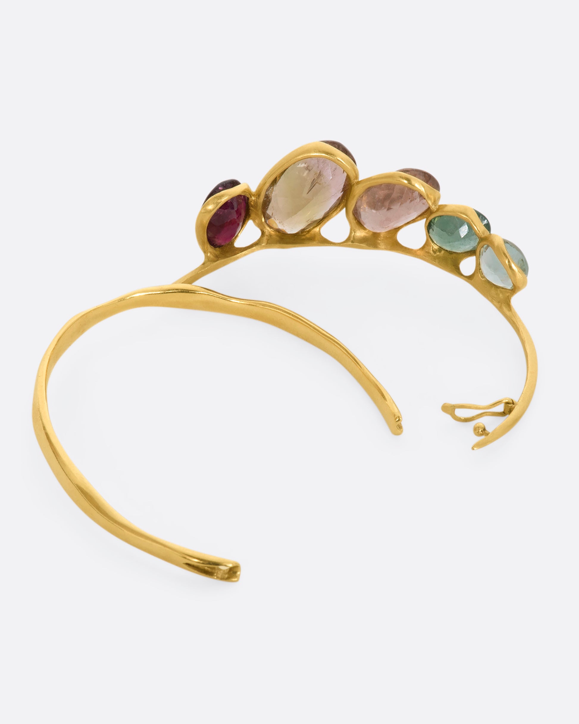 A yellow gold hinged bracelet crowned with five large different color tourmalines. View open.