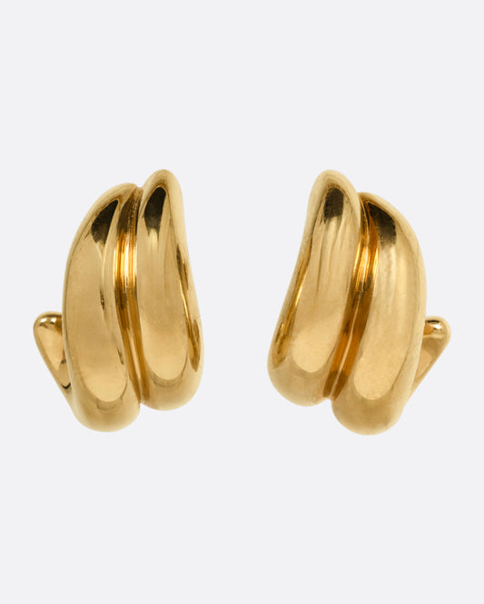 A pair of yellow gold curved huggie earrings, shown from the front.