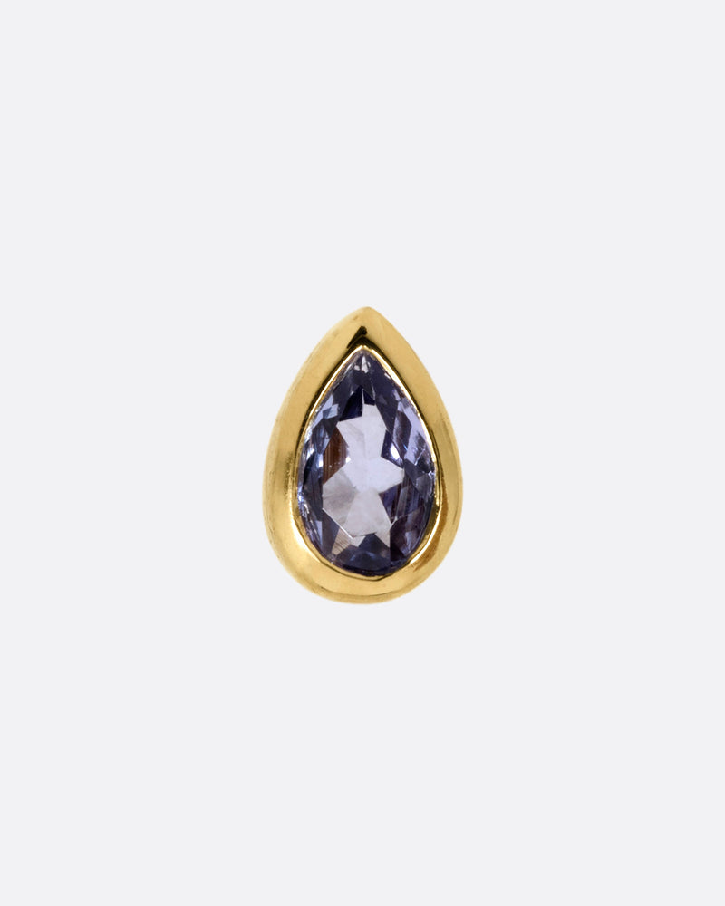 A yellow gold teardrop shaped bezel set tanzanite stud earring. Shown from the front.