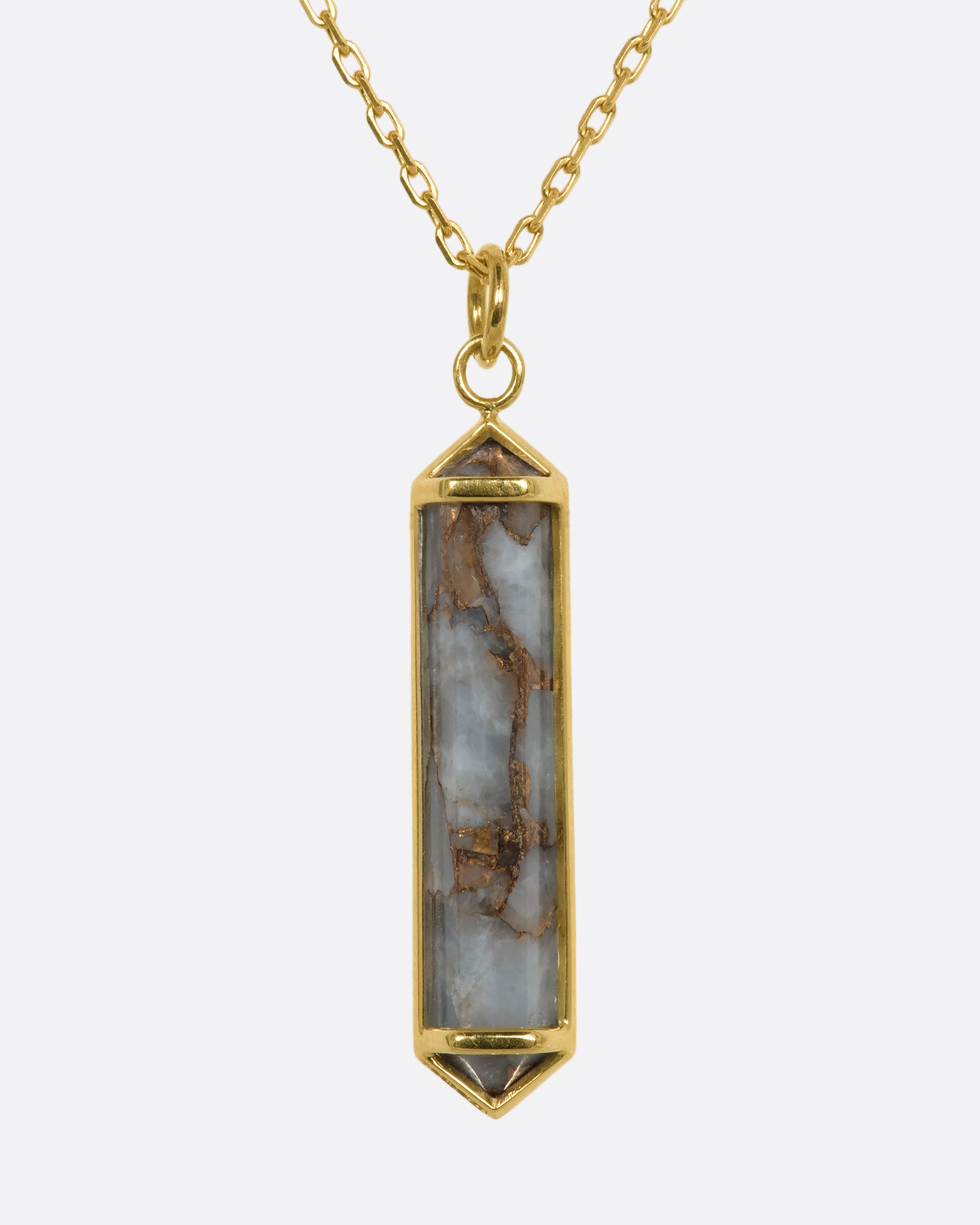 A yellow gold necklace with a geometric pink opal pendant. View from the front.